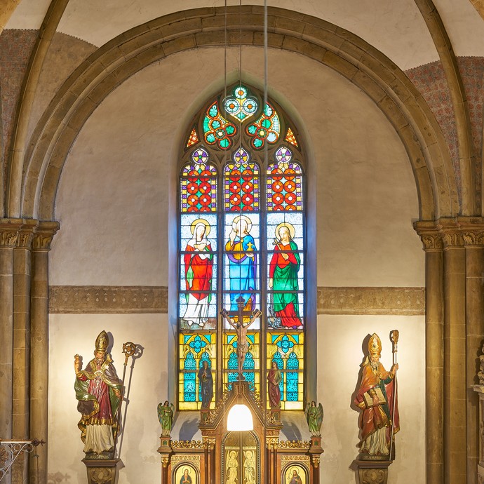 Kirchenfenster des Stifts Asbeck. Links und rechts neben dem Fenster befinden sich zwei Heiligenfiguren. © Münsterland e.V., Foelting.