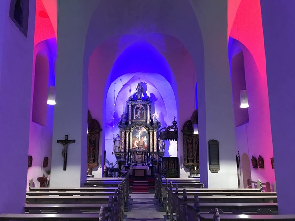 Der Hochaltar der Pfarrkirche St. Nikolaus. Das Innere der Kirche ist in blauem und rotem Licht erstrahlt. © Thomas Niemand.
