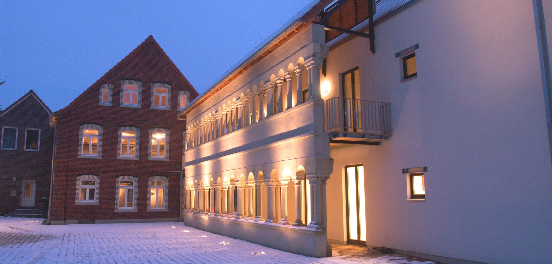 Abendliche Stimmung am Stift Asbeck. Zu sehen ist der rekonstruierte Doppelkreuzgang. © Archiv Heimatverein Asbeck e.V.
